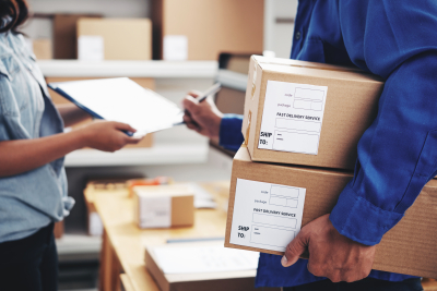 courier with parcels signing document in delivery service office