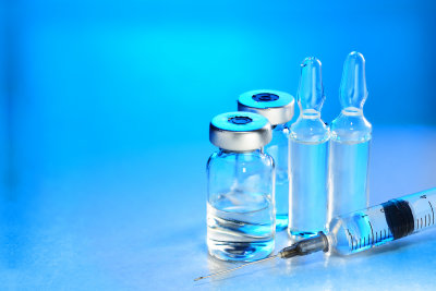 medical vials for injection with a syringe and ampules on blue background